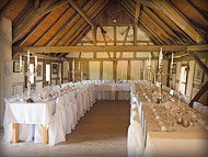 Der rustikale Hochzeitsraum mit eleganter Tischdekoration, Stuhlhussen und Kerzenständern