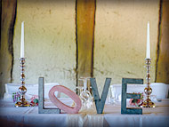Große "LOVE - Letters" als Tischdekoration für den Brauttisch, flankiert von 1-armigen, versilberten Kerzenständern