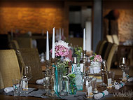 Stimmige Hochzeitsdekoration mit grauem Tischläufer, Vasen und einzelnen Kerzenständern